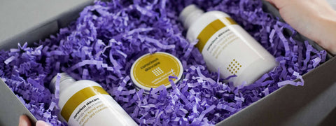 Our range of skincare gift sets include this luxury body wash gift set with white glass bottles and purple zig zag shred
