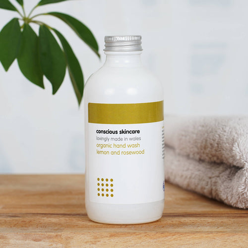 Organic Hand Wash in a white glass bottle on wooden table