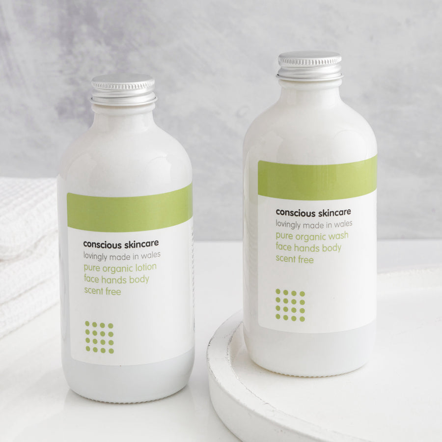 Fragrance Free Body Wash and Fragrance Free Body Lotion in white glass bottles on white table
