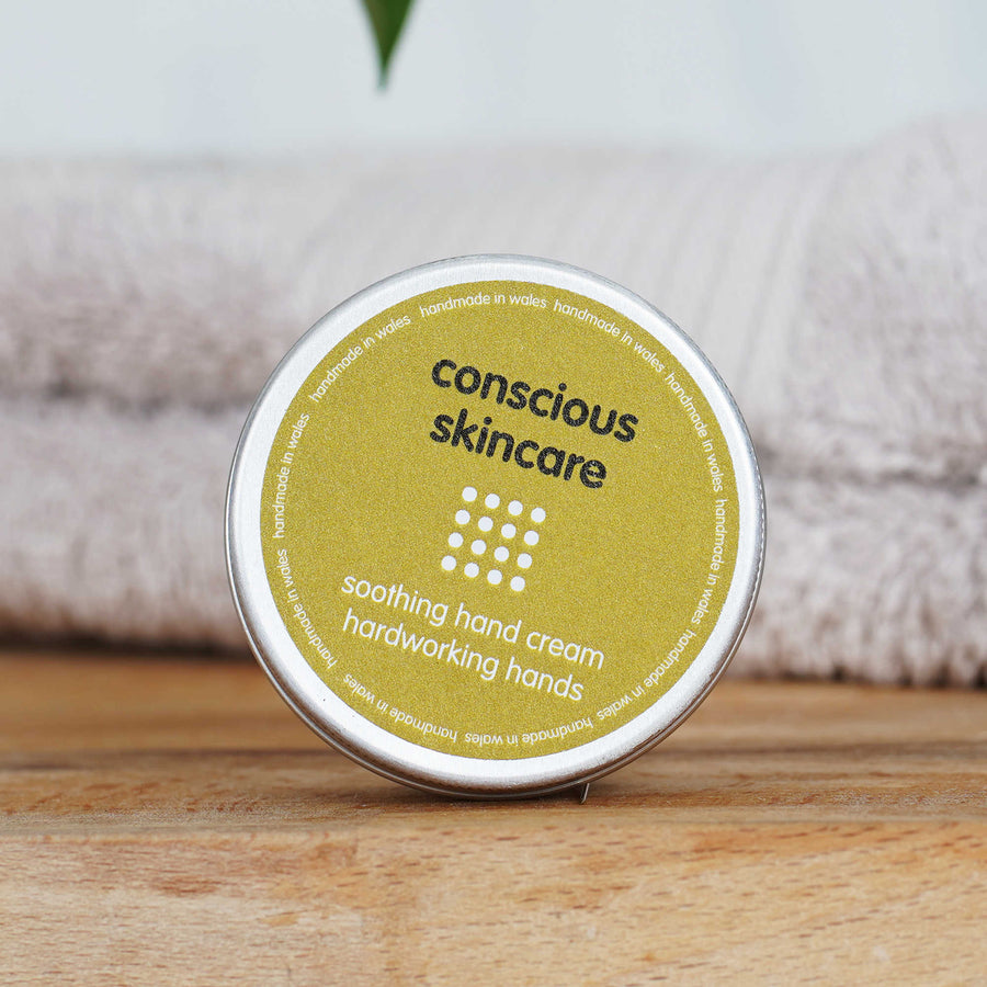 Hard Working Hand Cream in a plastic free tin on wooden table with towel