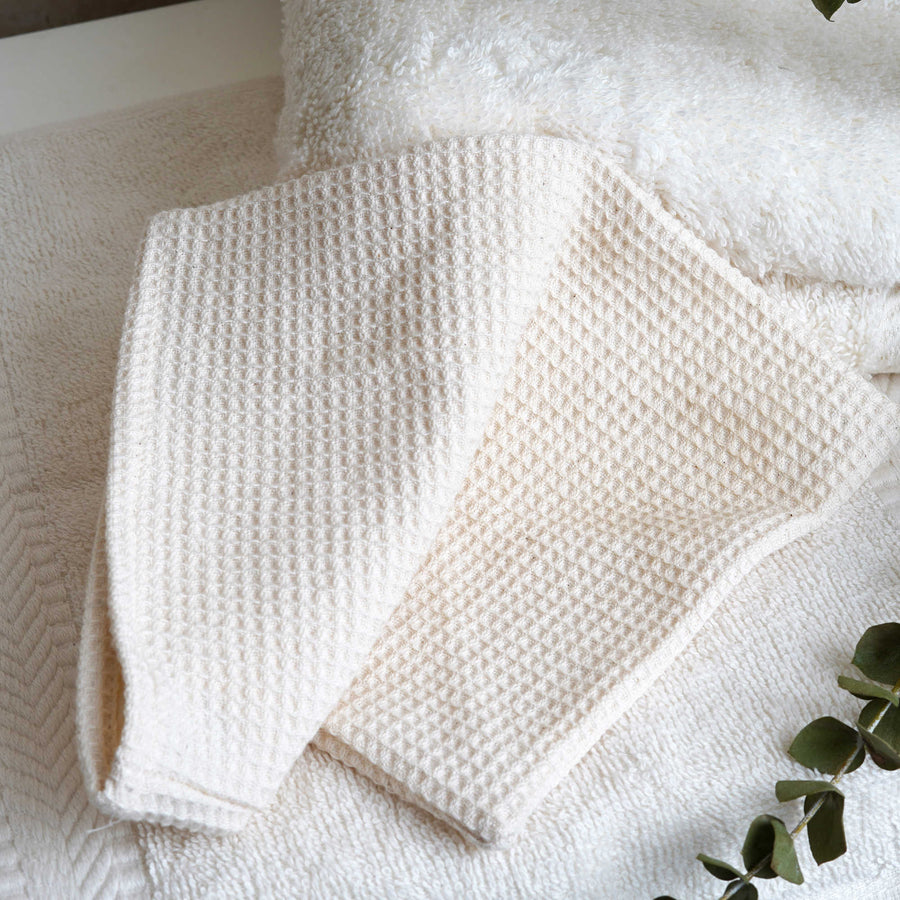 organic cotton face mitt with white towel and plant