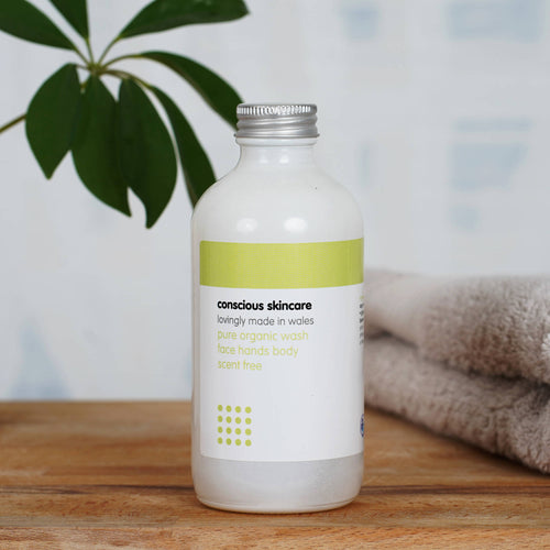 Pure Fragrance Free Body Wash in a white 235ml glass bottle on wooden table