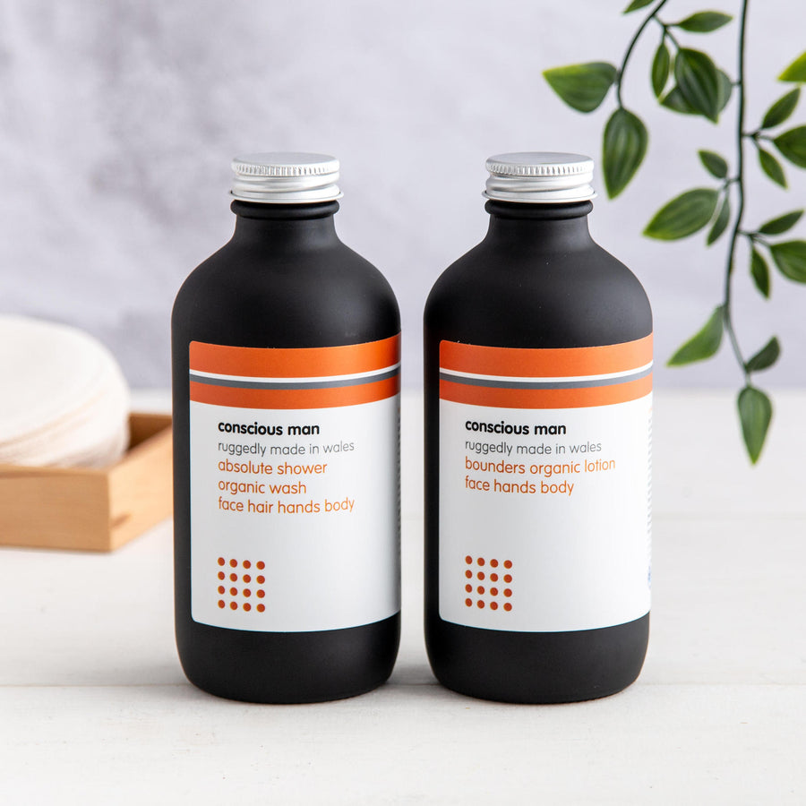 Bounders men’s body moisturiser and Absolute Men’s Shower Gel on a wooden table with towel and plant