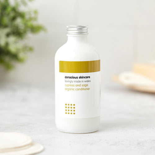 Cypress and sage natural conditioner in white glass bottle with silver cap