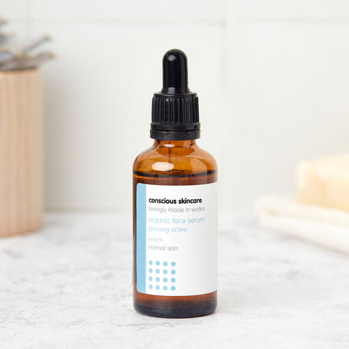 enrich natural face serum in amber glass bottle with black dropper