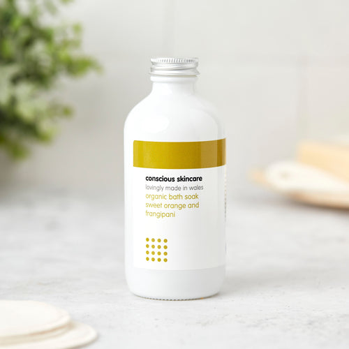 Sweet orange and frangipani natural bath soak in a white glass bottle with aluminium screw cap